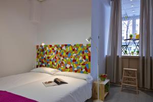1 dormitorio con 1 cama con cabecero colorido en Pil Pil Hostel Bilbao, en Bilbao