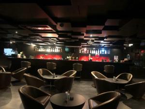 um restaurante com mesas e cadeiras e um bar em Cocoon Luxury Business Hotel em Dhanbad