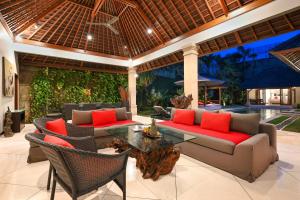 un patio al aire libre con sofás y una mesa en Villa Zanissa, en Seminyak