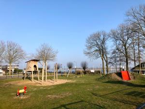 un parco giochi con un cavallo giocattolo in un parco di Bed and Breakfast De Biesbosch - in 't Riet a Drimmelen