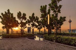 a walkway in a park with trees and a sunset at Urban hive in Bukit Bintang I Robertson Residence in Kuala Lumpur