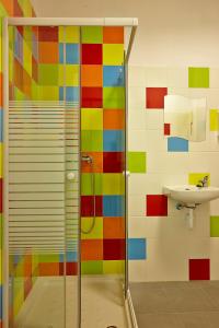 y baño colorido con ducha y lavamanos. en Pil Pil Hostel Bilbao, en Bilbao