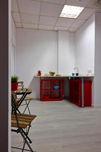 una habitación vacía con armarios rojos y sillas en una oficina en Pil Pil Hostel Bilbao, en Bilbao