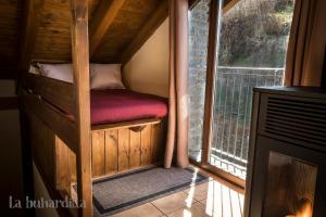 uma pequena cama num quarto com uma janela em Abadía de Montenartró Apartamentos em Montenastró