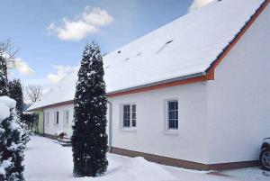 ein weißes Haus mit einem schneebedeckten Dach in der Unterkunft Apartment Gingst 1 in Haidhof