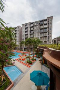 an apartment complex with two pools and umbrellas at La Habana in Hua Hin