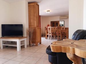 a living room with a television and a table at Lacs de l'eau d'heure Amiral 24 in Erpion