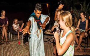 Un uomo vestito da inieval in piedi accanto a una ragazza di M'hamid Desert Camp Tours a M'Hamid