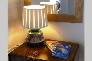 een lamp bovenop een tafel bij Rural 17th century barn studio apartment in Cheriton Bishop