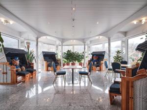 a room with chairs and a table and some plants at TIPTOP Hotel am Hochrhein in Bad Säckingen