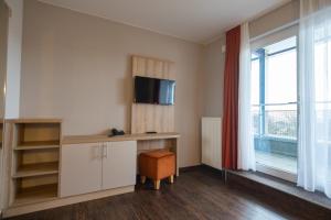 a room with a desk and a tv and a window at Hotel Wikinger in Zempin