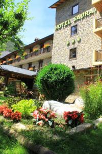 a hotel courtyard with flowers in front of a building at Hotel Saurat in Espot