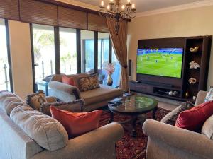 ein Wohnzimmer mit Sofas und einem Flachbild-TV in der Unterkunft Villa Moncharê in Margate