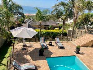 einen Pool mit Liegestühlen und einem Sonnenschirm in der Unterkunft Villa Moncharê in Margate