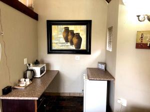 una cocina con una foto de jarrones en la pared en Gaggle Inn Guest Lodge, en Kroonstad