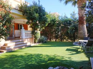 einen Hinterhof mit einer Liegewiese mit einem Tisch und Stühlen in der Unterkunft Los Alamos Orangecosta in Peñíscola