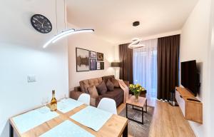 een woonkamer met een tafel en een bank bij LAGUNA Apartament Polanica Residence 41 in Polanica-Zdrój