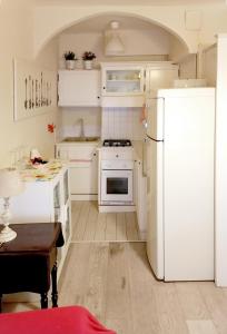 a kitchen with white appliances and a white refrigerator at Porta Venezia & Giardini Montanelli Cozy Flat in Milan
