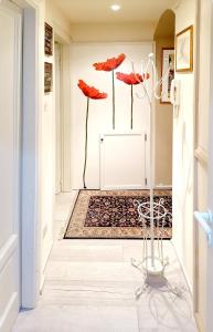 a hallway with red flowers on the wall at Porta Venezia & Giardini Montanelli Cozy Flat in Milan