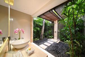 y baño con bañera y lavamanos. en Villa Zanissa en Seminyak