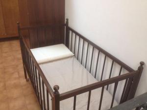 Casa di Anchiano في بورغو آه موتزانو: سرير خشبي عليه وسادة بيضاء