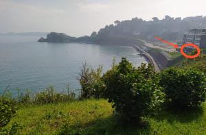 a red sign on the side of a body of water at Appartement Vue Mer, RDC, Plage de Trestrignel in Perros-Guirec