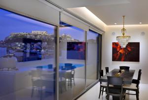 a dining room with a table and a view of the city at ALTO PSYRRI PENTHOUSE by K&K in Athens