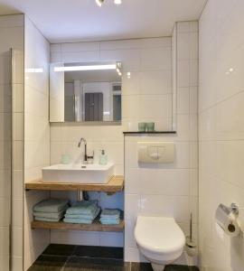 une salle de bain blanche avec un lavabo et des toilettes dans l'établissement Vlier 08 - Klepperstee Ouddorp NOT INTENDED FOR COMPANY OR WORK-RELATED STAYS, à Ouddorp