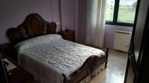 ein Schlafzimmer mit einem Bett in einem Zimmer mit Fenster in der Unterkunft Piso cerca de la playa in Boiro