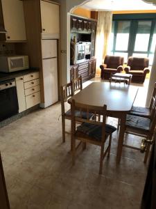 eine Küche und ein Wohnzimmer mit Tisch und Stühlen in der Unterkunft Piso cerca de la playa in Boiro