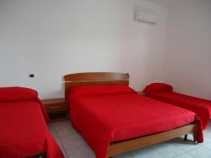 een kamer met 2 bedden met rode dekens bij AFFITTACAMERE GELINDO in Silvi Marina