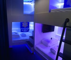 a bedroom with a bunk bed with a purple light at Modular Rooms in Madrid