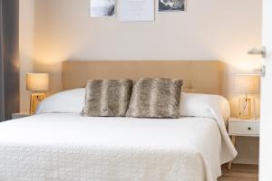 um quarto com uma cama branca com duas almofadas em Apartment an der Altstadt (#2) em Hameln