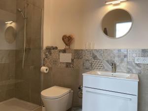 Un baño con inodoro, lavabo y espejo. en Apartment an der Altstadt (#2), en Hameln 4 fotos más
