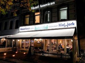 a restaurant with tables and chairs in front of a building at Hotel American in Venlo