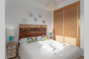 um quarto com uma cama branca e uma cabeceira em madeira em Casa Elsi Prachtig vernieuwd appartement em Manilva