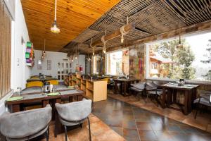 un ristorante con tavoli e sedie in legno e finestre di The Nature's Green Resort, Bhimtal, Nainital a Nainital