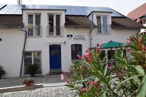 a hotel with a blue door and flowers at Hotel Sammeth Bräu in Weidenbach