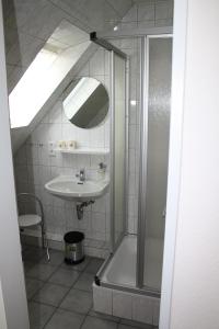 ein Bad mit einer Dusche und einem Waschbecken in der Unterkunft Pension Engelmann in Neuharlingersiel