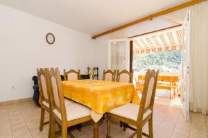 comedor con mesa amarilla y sillas en Apartments Kuzma, en Smokvica