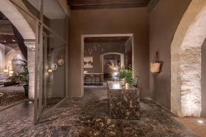 a hallway of a home with a stone floor and a table at Hotel Can Cera in Palma de Mallorca