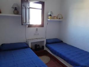 a room with two blue beds and a window at CASA PIZZI in Agua Amarga +19 photos