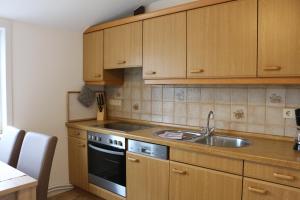 a kitchen with wooden cabinets and a sink at Am Storchennest in Damnatz