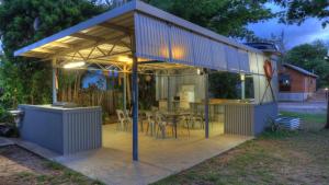 a pavilion with a table and chairs in a backyard at Kookaburra Holiday Park in Cardwell