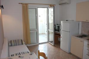 una pequeña cocina con nevera blanca y mesa en Omiš Duće sandy beach apartments Mare, en Omiš