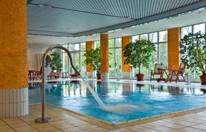 a swimming pool with a fountain in a building at Congress Hotel Weimar by Mercure in Weimar