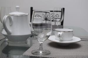 a table with two wine glasses and a cup on it at Villa 307 2 room apartment in Matara
