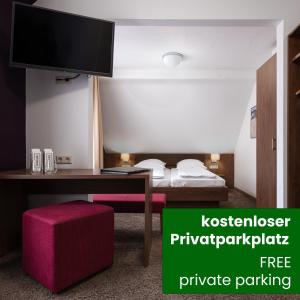 a room with a desk and a bed with a tv at Boutique Hotel Societe in Baden-Baden