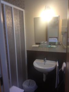 ein Bad mit einem Waschbecken, einem Spiegel und einer Dusche in der Unterkunft Hotel Terme Belvedere in Abano Terme