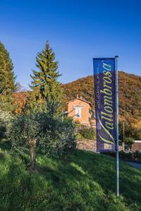 a sign in the grass next to a tree and a house at Wine & Art Relais Vallombrosa in Castelrotto